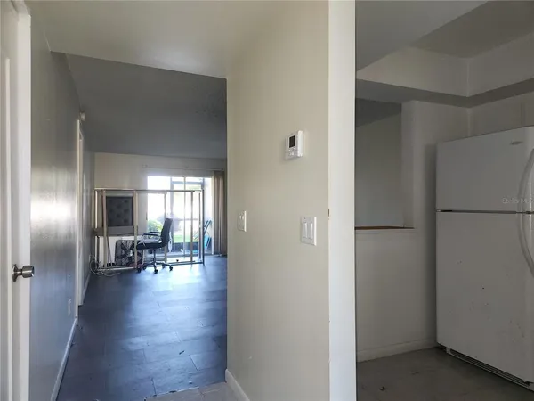 a view of kitchen with refrigerator and wooden floor