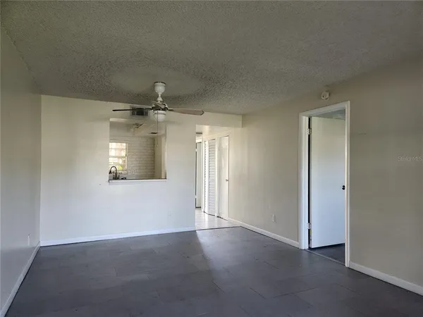 an empty room with windows and fan