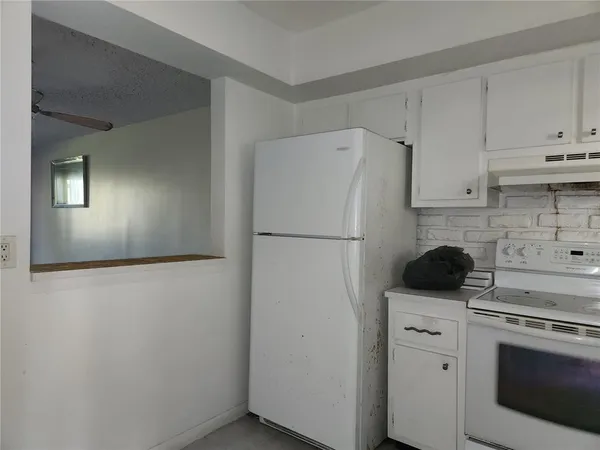 a kitchen with a refrigerator sink stove and cabinets