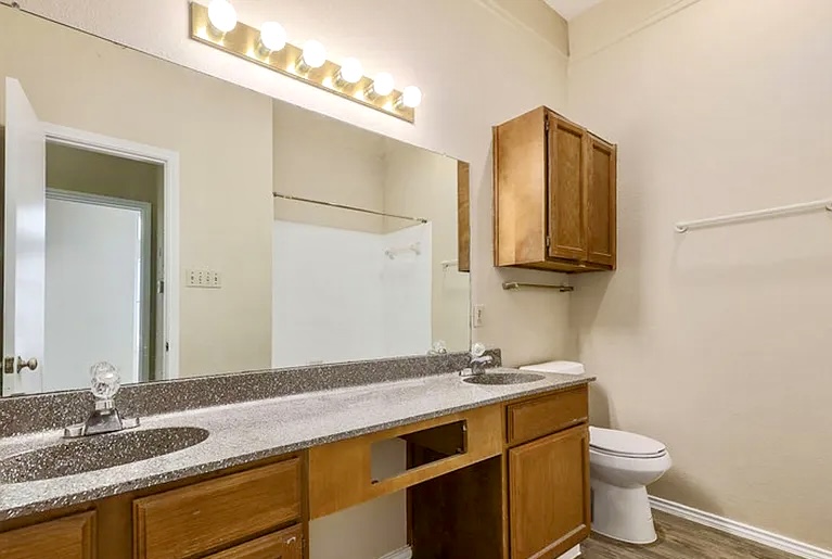 2802 Nueces Street, Unit 211 Austin, TX 78705 - Photo 12 of 14 a bathroom with a granite countertop sink toilet and a mirror