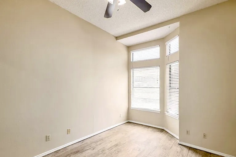 2802 Nueces Street, Unit 211 Austin, TX 78705 - Photo 13 of 14 an empty room with a window and chandelier fan