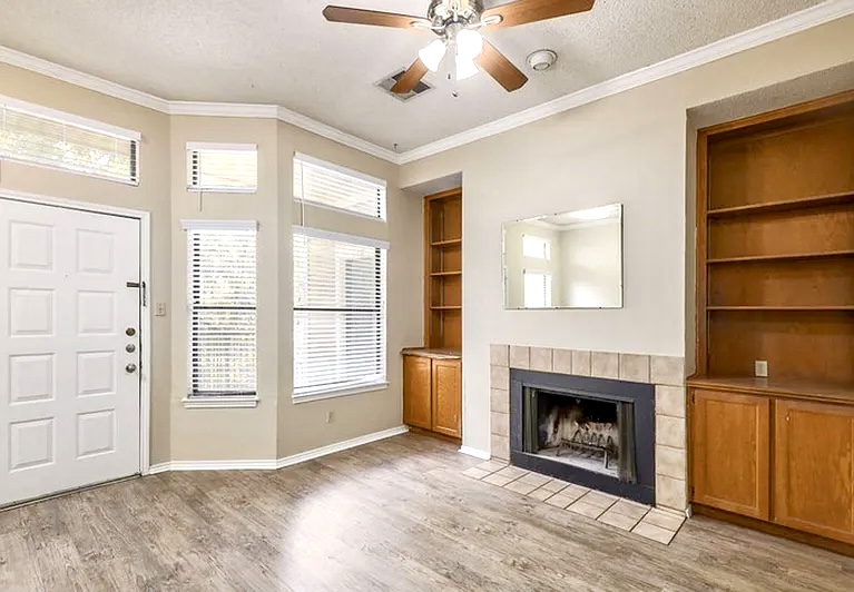 2802 Nueces Street, Unit 211 Austin, TX 78705 - Photo 8 of 14 a view of an empty room with a fireplace and a window
