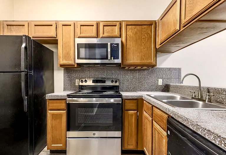 2802 Nueces Street, Unit 211 Austin, TX 78705 - Photo 10 of 14 a kitchen with a sink a stove and refrigerator