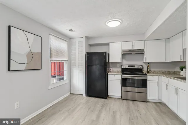 a kitchen with a refrigerator and a stove top oven