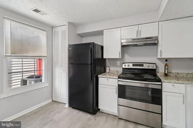 a kitchen with a stove refrigerator and microwave