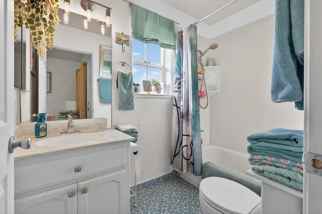 a spacious bedroom with a bed and a chandelier