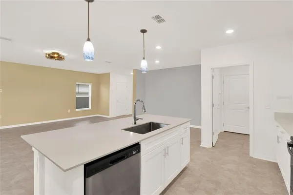 a kitchen with granite countertop a sink a counter space and wooden floor