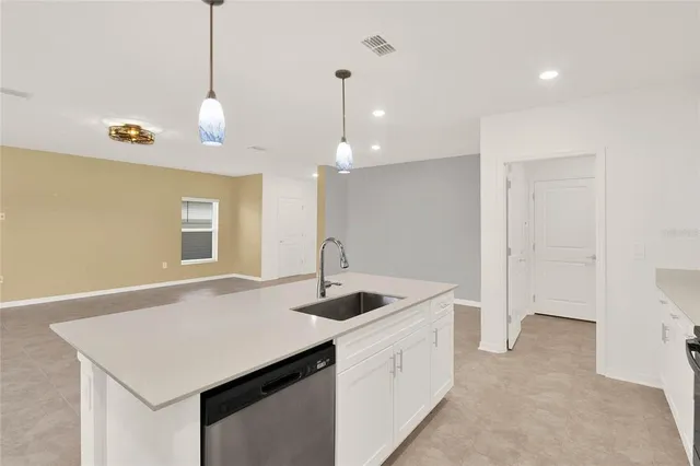 a kitchen with granite countertop a sink a counter space and wooden floor