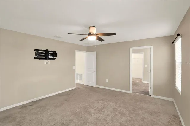 a view of a livingroom with a ceiling fan and window
