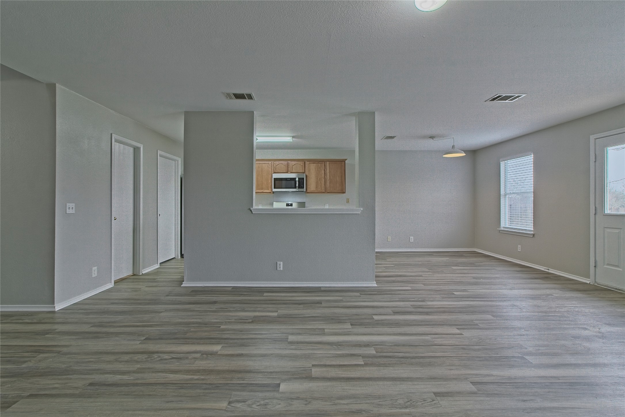 232 Brickyard Lane Jarrell, TX 76537 - Photo 10 of 31 Bright, open-concept living space with durable laminate flooring transitions seamlessly into the kitchen.