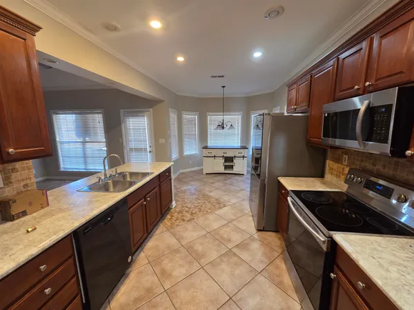 a kitchen with stainless steel appliances granite countertop a sink stove and refrigerator