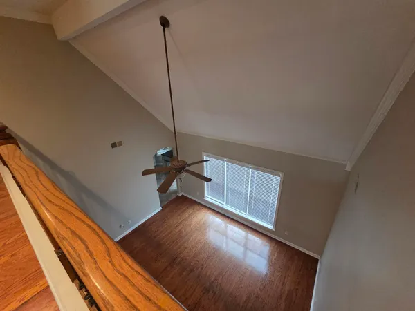 a view of an empty room with wooden floor