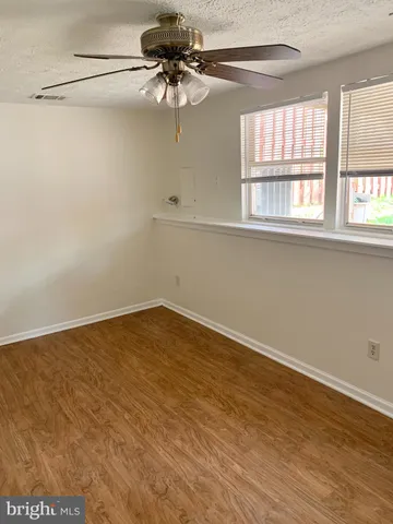 a view of a big room with wooden floor closet and chandelier fan
