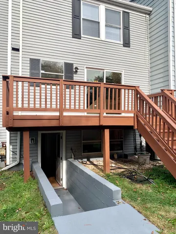 a view of a house with a deck and a small yard