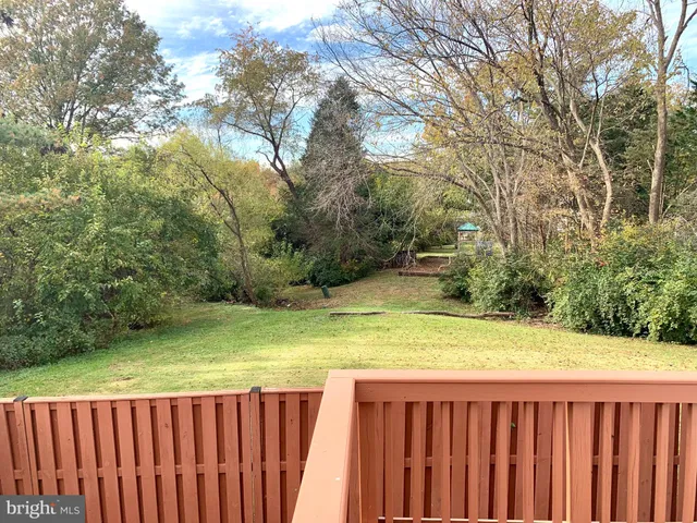 a view of a yard with wooden fence