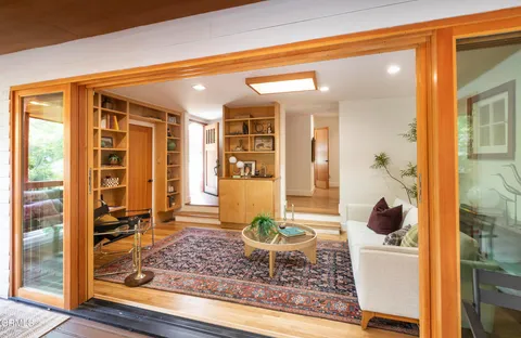 a living room filled with furniture and a floor to ceiling window