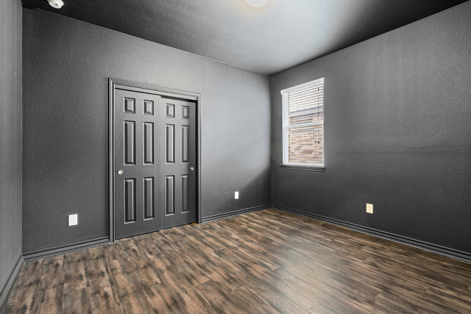 204 Tulum Terrace Leander, TX 78641 - Photo 16 of 22 Unfurnished bedroom featuring a textured wall, dark wood-type flooring, and a closet