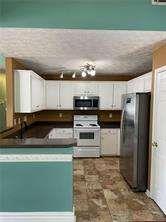 836 Freedom Walk Locust Grove, GA 30248 - Photo 8 of 21 a kitchen with stainless steel appliances granite countertop a sink a stove a microwave and a refrigerator