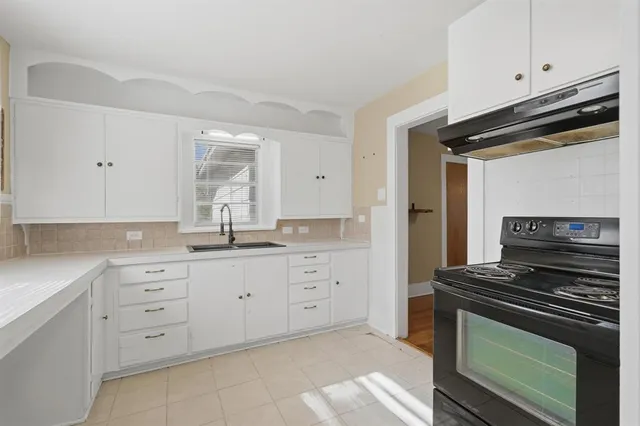 a kitchen with cabinets appliances and a window