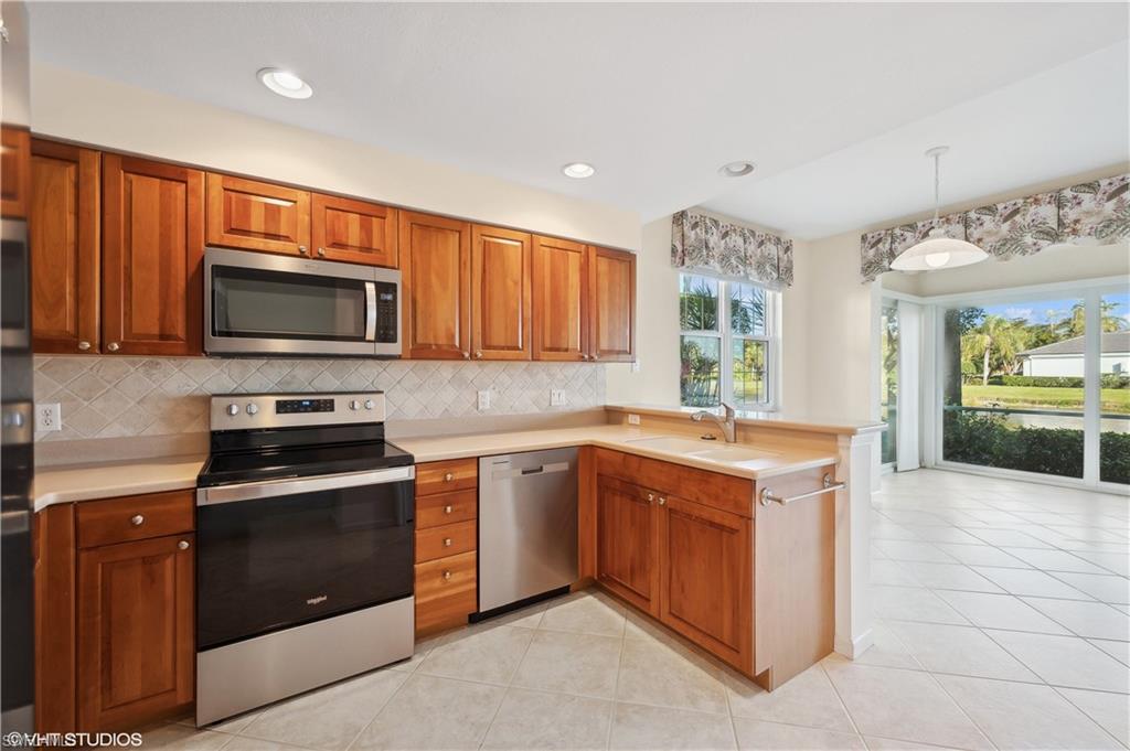 22931 Rosedale Drive, Unit 101 Estero, FL 34135 - Photo 13 of 35 a kitchen with a stove microwave and sink