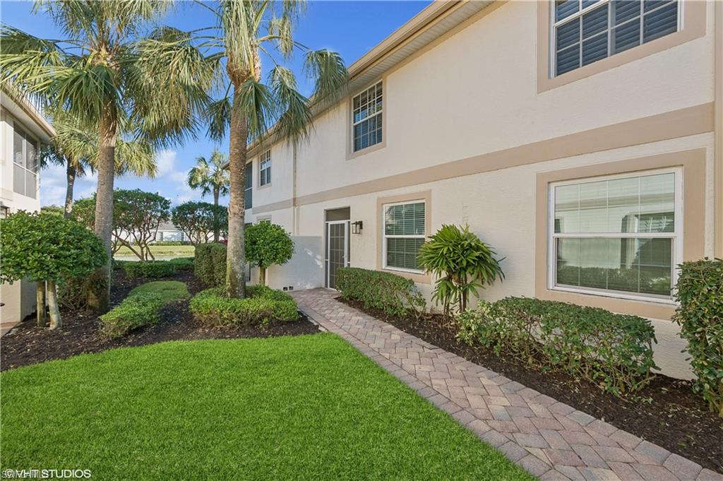 22931 Rosedale Drive, Unit 101 Estero, FL 34135 - Photo 2 of 35 a view of a house with a yard and potted plants
