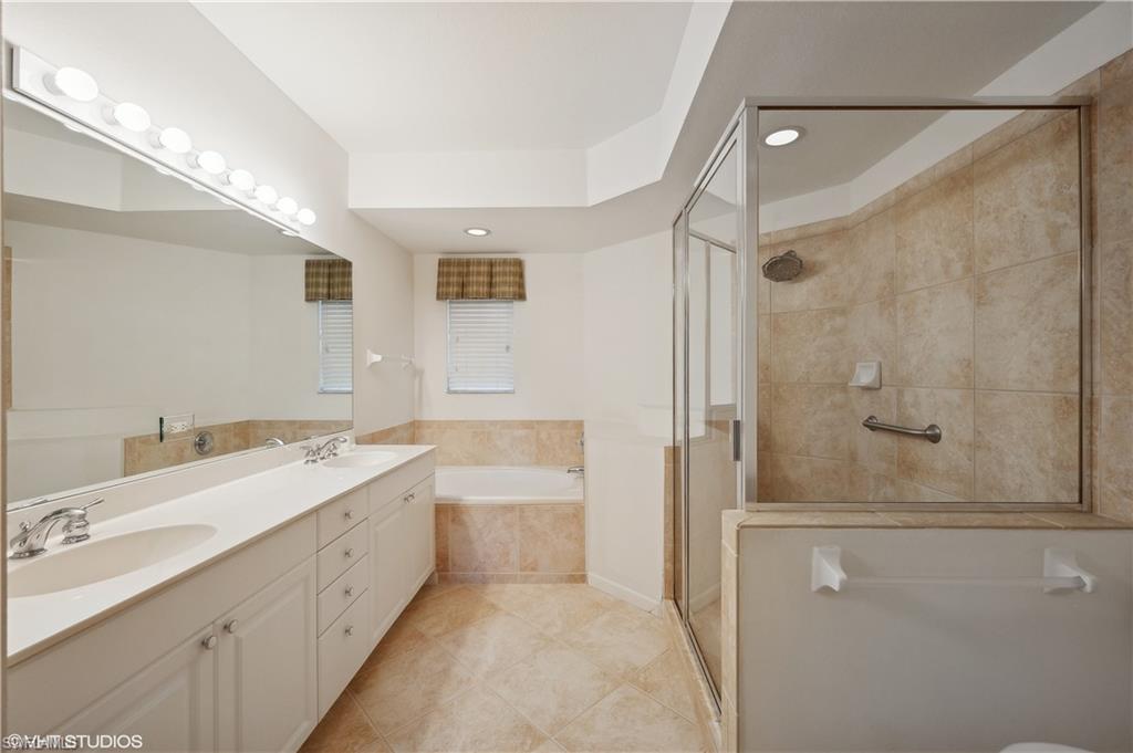 22931 Rosedale Drive, Unit 101 Estero, FL 34135 - Photo 24 of 35 a bathroom with a double vanity sink a toilet and shower