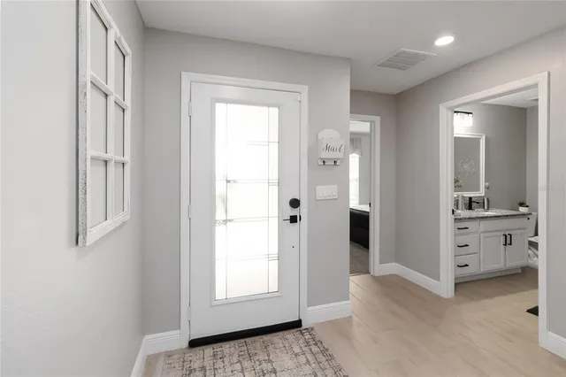 a view of a hallway with windows and chandelier