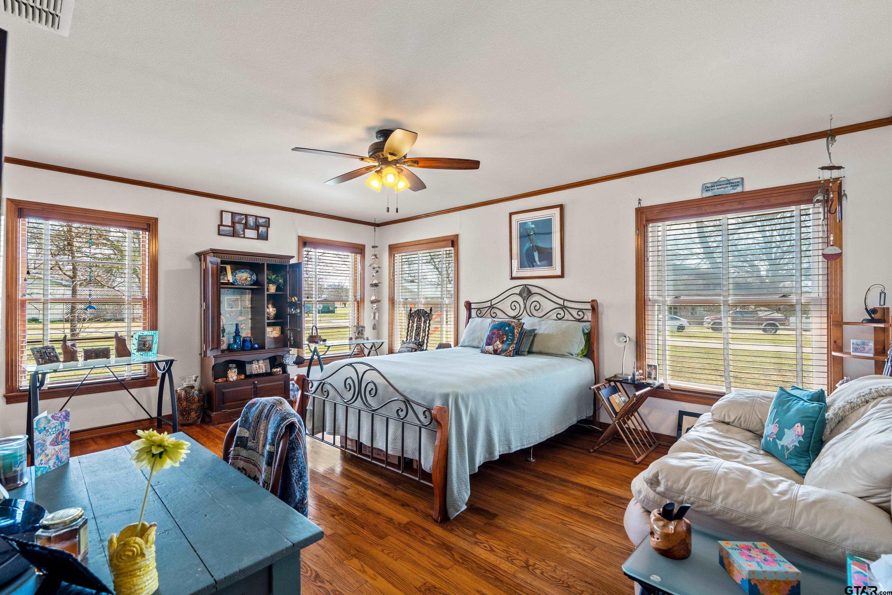 609 East Quitman Street Alba, TX 75410 - Photo 27 of 38 a bedroom with a bed a couch and a large window