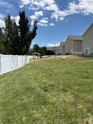 641 East Greystone Way Tooele, UT 84074 - Photo 23 of 30 Expansive grassy yard area featuring a white vinyl fence