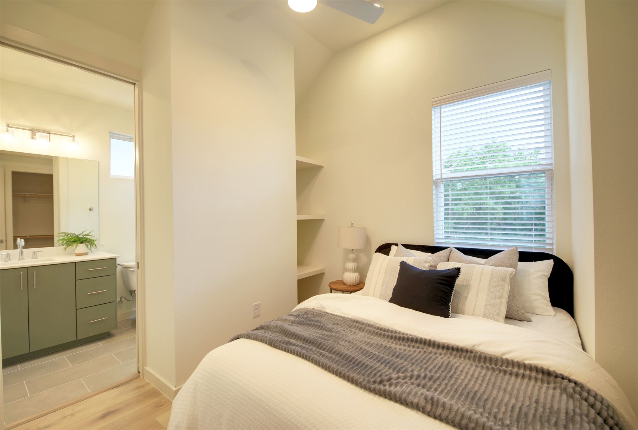6802 Montana Street, Unit 2 Austin, TX 78741 - Photo 11 of 13 A well-lit bedroom with vaulted ceilings and warm wood flooring adjoins a contemporary bathroom.