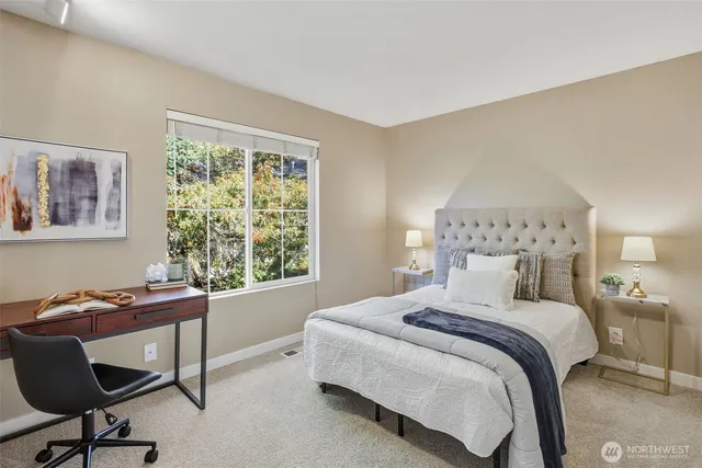 a bedroom with a bed a desk and chair next to a window