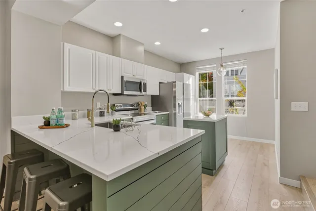 a kitchen with kitchen island a sink appliances and cabinets