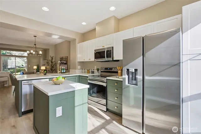 a kitchen with kitchen island a sink stove and refrigerator