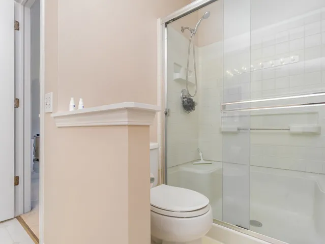 a bathroom with a granite countertop shower and a toilet