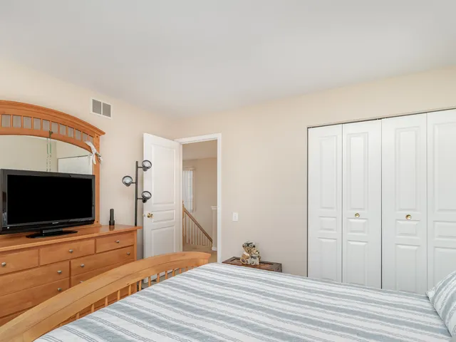 a bedroom with a flat screen tv and a dresser