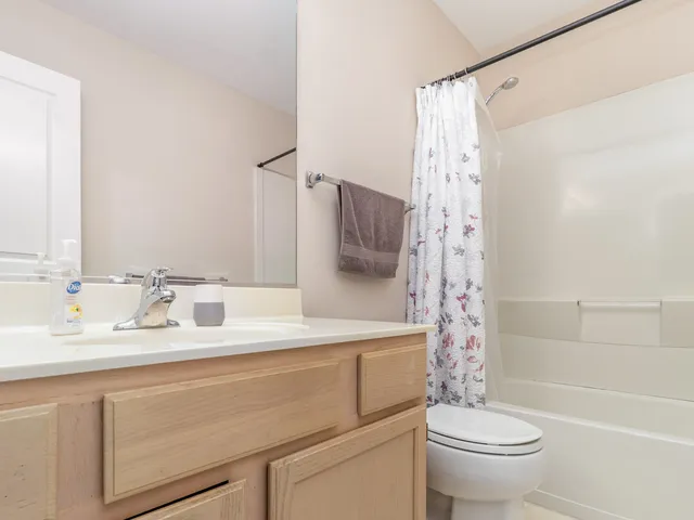 a bathroom with a sink toilet double vanity and shower