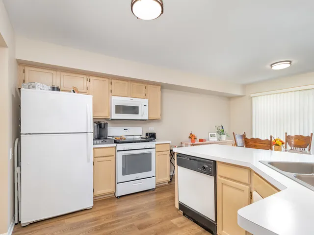 a kitchen with a sink a stove a refrigerator and white cabinets
