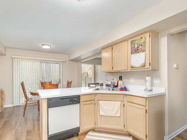 a kitchen with stainless steel appliances white cabinets sink and wooden floor