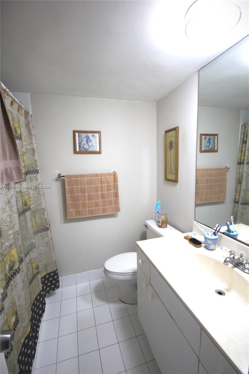 5161 Collins Avenue, Unit 603 Miami Beach, FL 33140 - Photo 11 of 56 a bathroom with a sink a toilet and mirror
