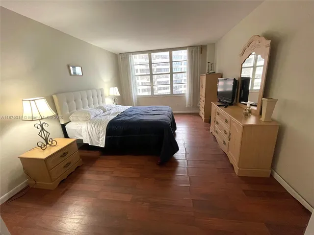 a bedroom with a bed window and flat screen tv
