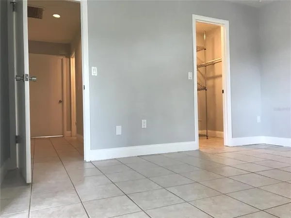 an empty room with windows and closet