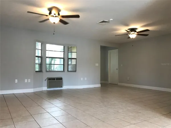 a view of a livingroom with a ceiling fan a ceiling fan and a window