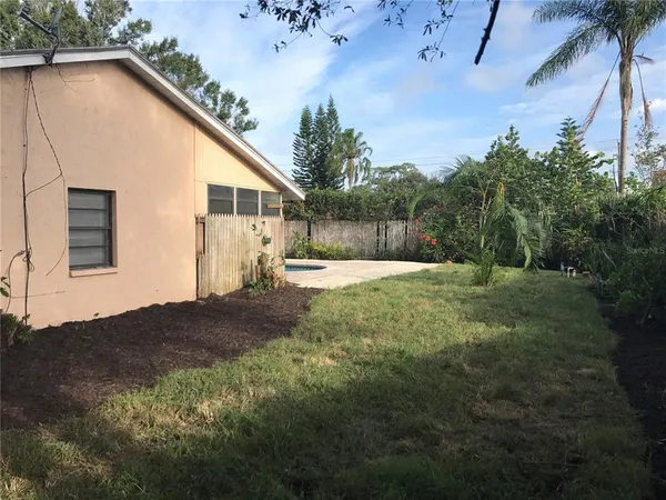 a view of backyard with a garden and trees