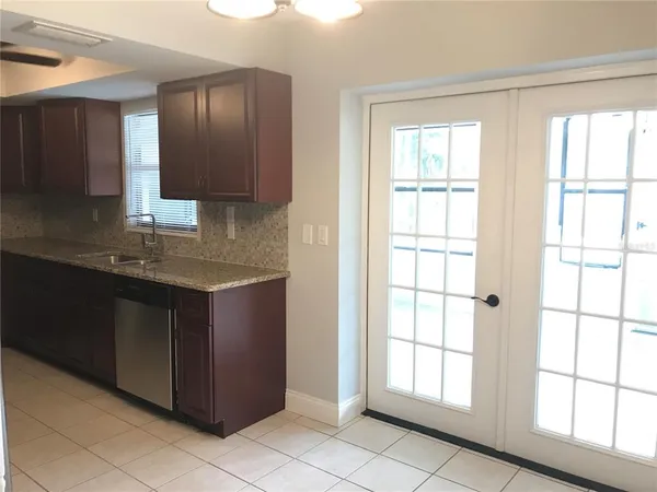 a kitchen with a sink window and cabinets