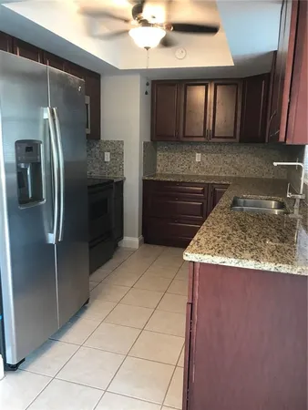 a kitchen with stainless steel appliances granite countertop a refrigerator and a sink