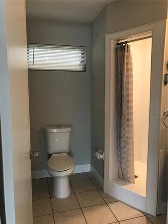 a white toilet sitting in a bathroom next to a window