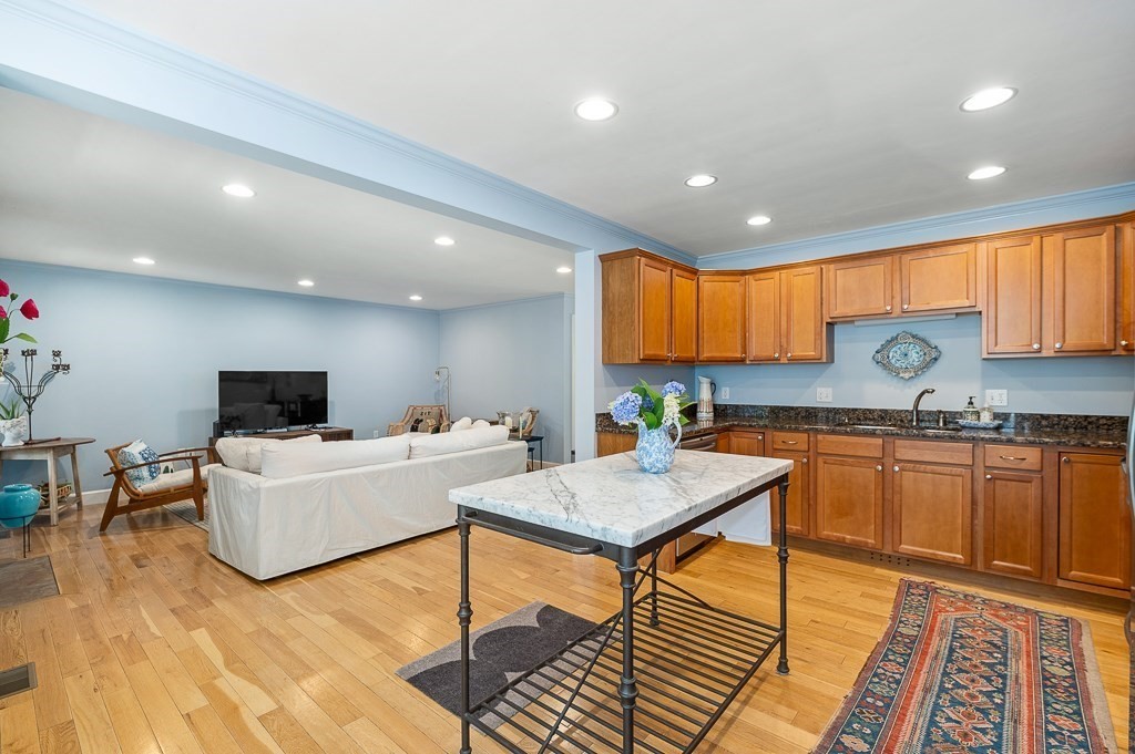 56 Summer Street, Unit A Manchester, MA 01944 - Photo 11 of 35 a kitchen with stainless steel appliances granite countertop a refrigerator sink and cabinets