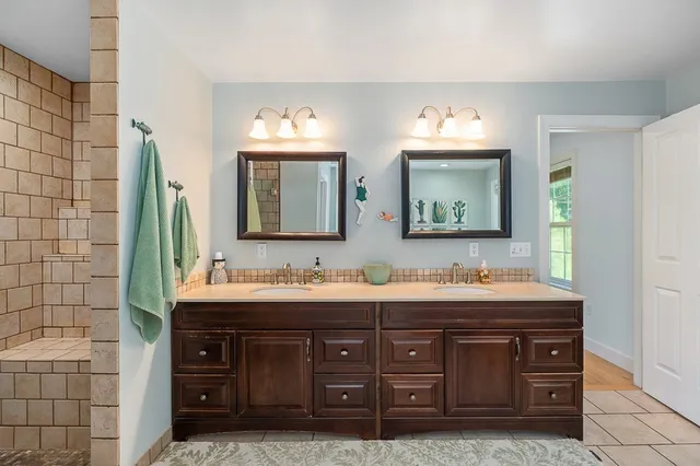 a bathroom with a double vanity sink and a mirror