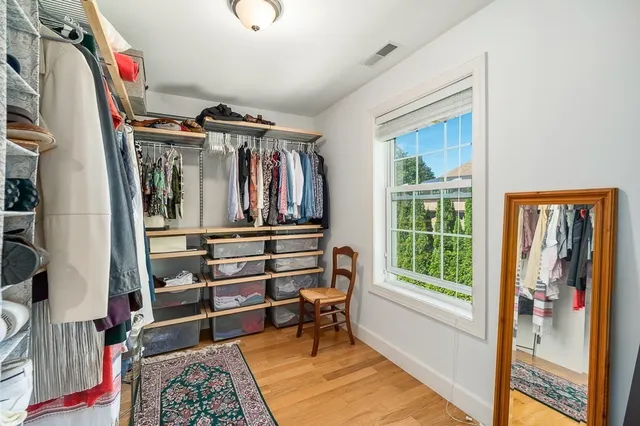 a view of walk in closet with clothes and shoes