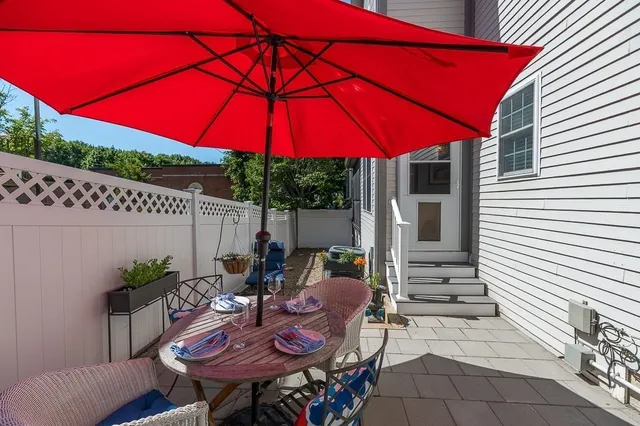 a view of a patio with table and chairs under an umbrella